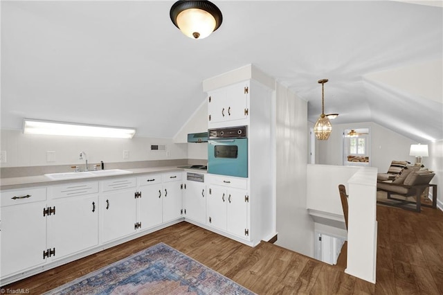 kitchen featuring dark wood-style flooring, a sink, white cabinetry, wall oven, and vaulted ceiling