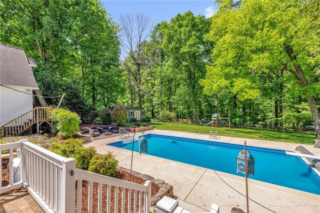 pool featuring fence, a patio, a storage unit, a playground, and an outbuilding