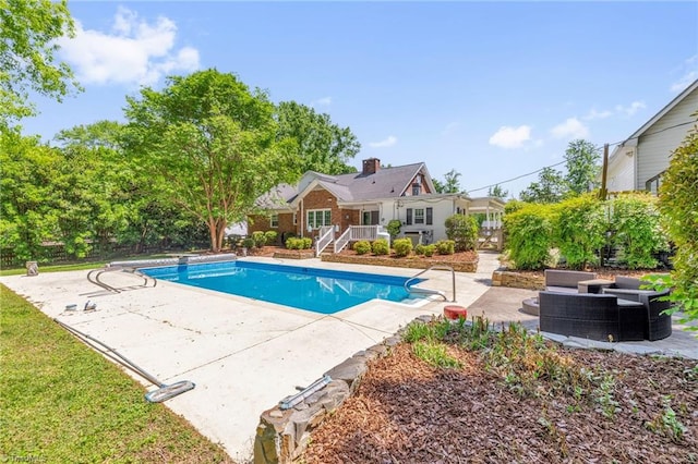 pool with a wooden deck, a patio, and an outdoor living space