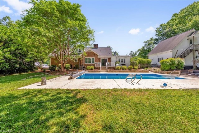 pool featuring a lawn and a patio area