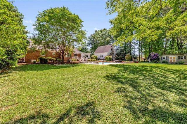 view of yard featuring an outbuilding and an outdoor pool
