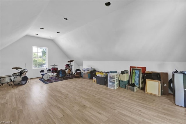 additional living space featuring vaulted ceiling and light wood-style flooring