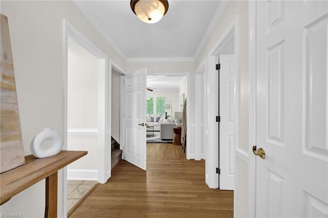 hall with ornamental molding and light wood-type flooring