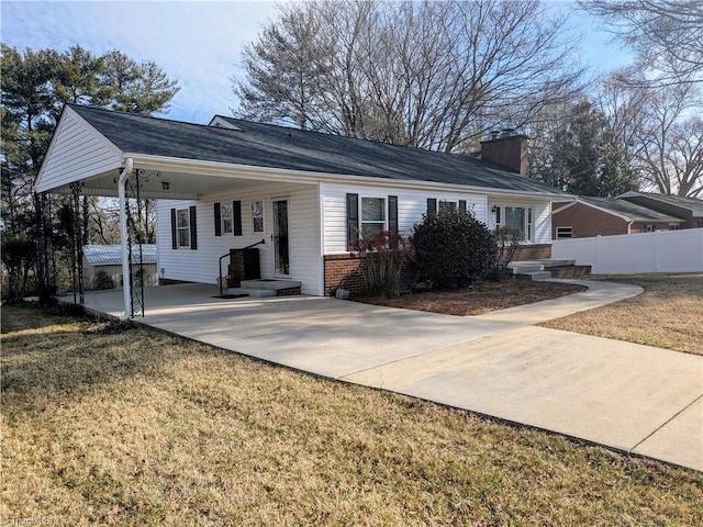 back of house featuring a carport, concrete driveway, brick siding, and fence