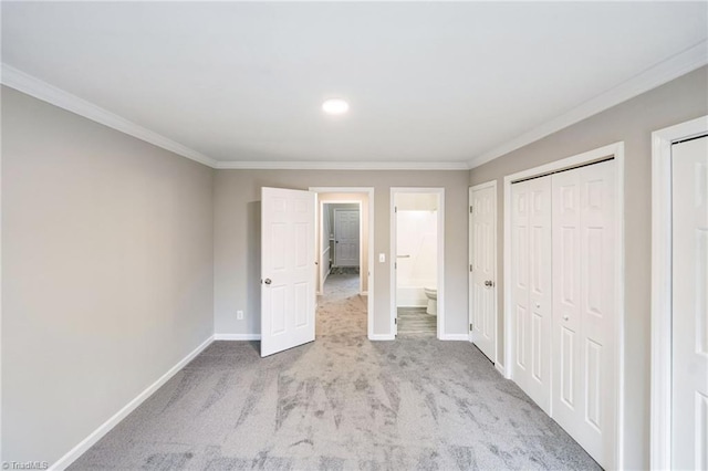 unfurnished bedroom with light colored carpet, crown molding, and connected bathroom