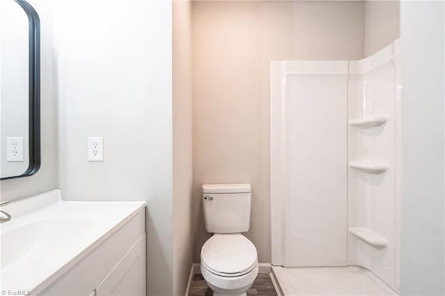 bathroom featuring vanity, toilet, wood-type flooring, and walk in shower