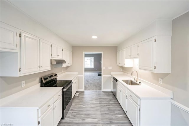 kitchen with sink, white cabinets, light hardwood / wood-style flooring, and appliances with stainless steel finishes