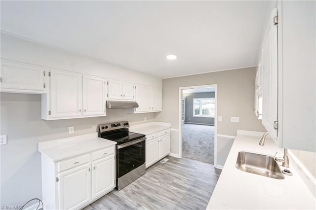 kitchen featuring stainless steel electric range, light wood-type flooring, white cabinetry, and sink