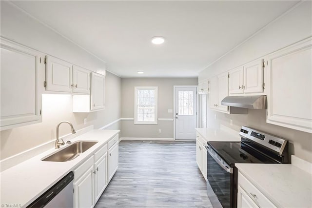 kitchen featuring sink, white cabinets, wood-type flooring, and appliances with stainless steel finishes