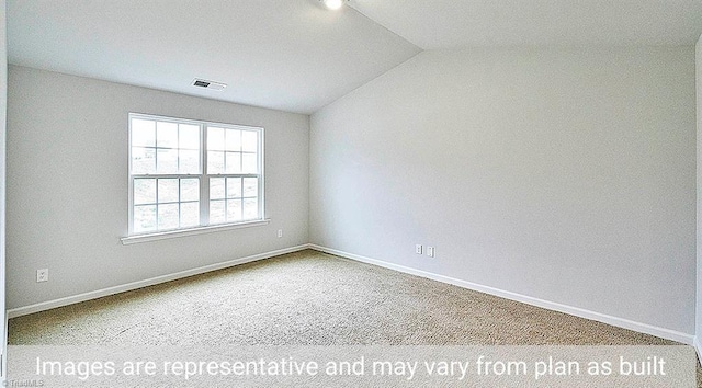 carpeted spare room featuring vaulted ceiling