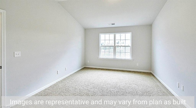 spare room featuring vaulted ceiling and carpet flooring