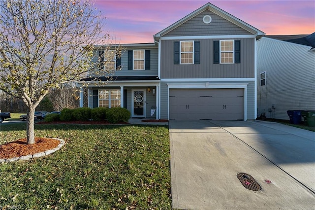 front of property featuring a yard and a garage