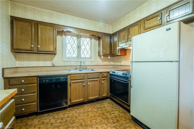 kitchen featuring wallpapered walls, electric range oven, black dishwasher, freestanding refrigerator, and a sink