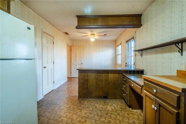 kitchen featuring a ceiling fan, visible vents, wallpapered walls, open shelves, and freestanding refrigerator