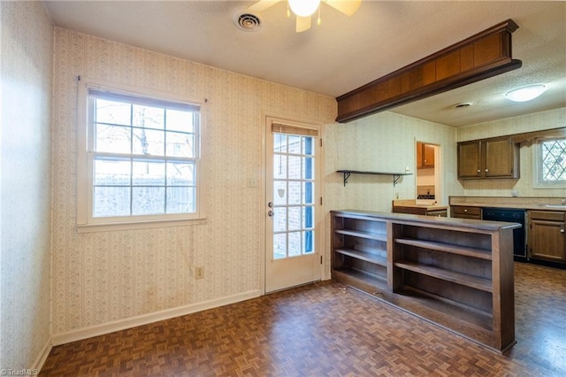 kitchen with a wealth of natural light, wallpapered walls, black dishwasher, and open shelves