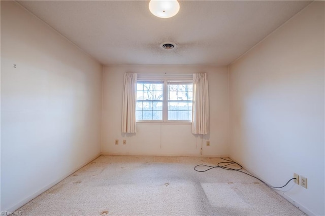 spare room featuring visible vents and carpet floors