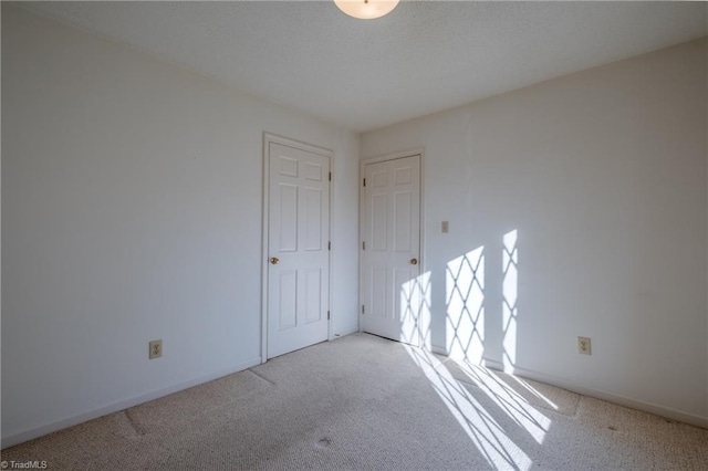 empty room with baseboards and carpet