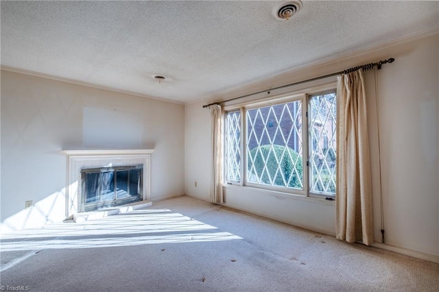 unfurnished living room with visible vents, ornamental molding, a textured ceiling, a glass covered fireplace, and carpet floors