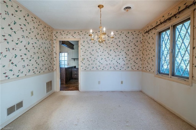 empty room with wallpapered walls, visible vents, and wainscoting