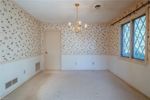 spare room with wallpapered walls, a wainscoted wall, and visible vents