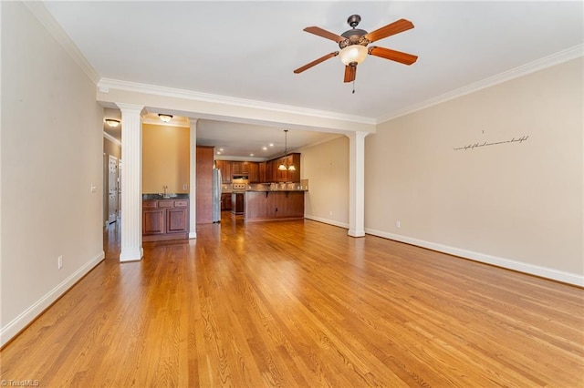 unfurnished living room featuring crown molding, light wood-type flooring, ceiling fan, and ornate columns