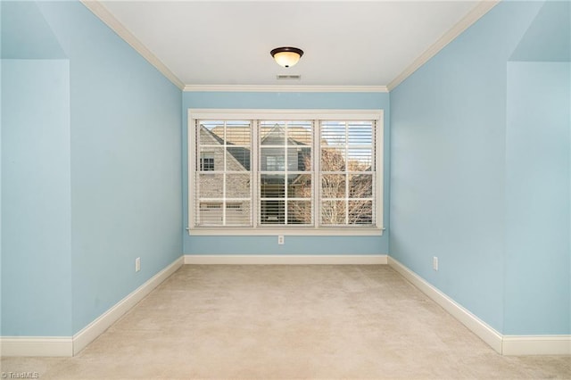 empty room featuring ornamental molding and light carpet