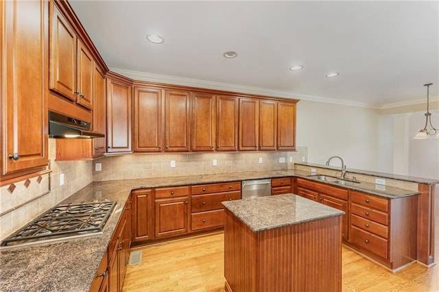 kitchen with stone counters, decorative light fixtures, sink, a center island, and stainless steel appliances