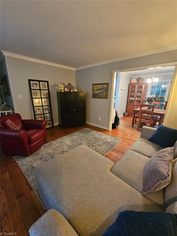 2007 Kildare Woods Dr, Greensboro, NC 27407 - living room featuring wood finished floors, crown molding, a chandelier, and baseboards