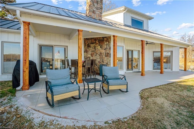 rear view of property with ceiling fan and a patio