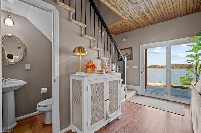 interior space featuring wooden ceiling, sink, wood-type flooring, and a water view