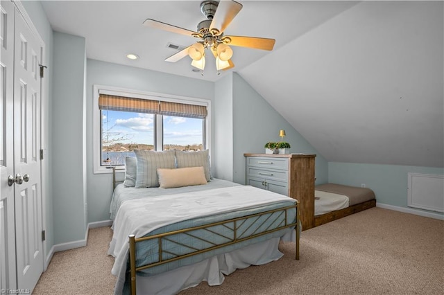 bedroom featuring ceiling fan, light colored carpet, a closet, and lofted ceiling