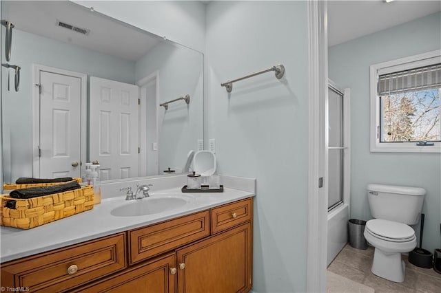 full bathroom with tile patterned floors, shower / bath combination with glass door, vanity, and toilet