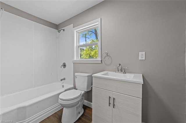 bathroom with shower / bath combination, wood finished floors, vanity, baseboards, and toilet