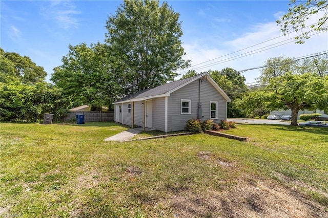 exterior space with fence, an outdoor structure, and a yard