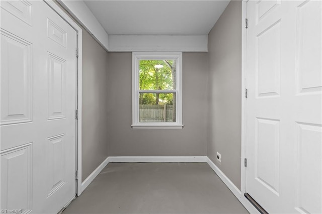 unfurnished bedroom featuring baseboards and finished concrete floors