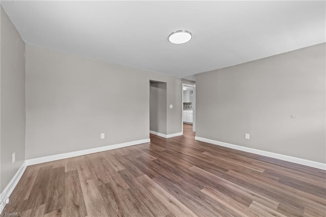 empty room featuring baseboards and wood finished floors