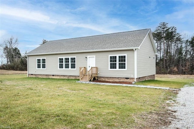 back of house featuring crawl space, a lawn, and roof with shingles