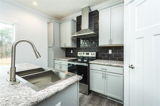 kitchen with crown molding, a sink, stainless steel electric stove, wall chimney exhaust hood, and dark wood-style flooring