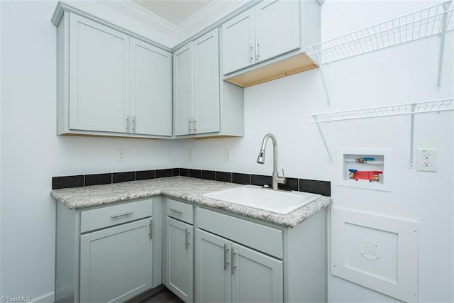 kitchen featuring crown molding, a sink, and light countertops