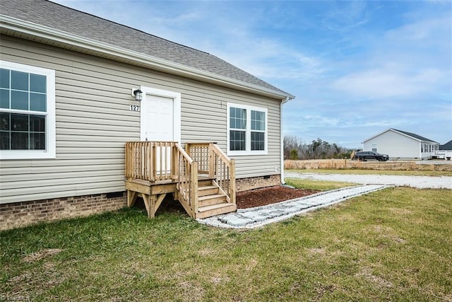 exterior space featuring a yard, crawl space, and a shingled roof