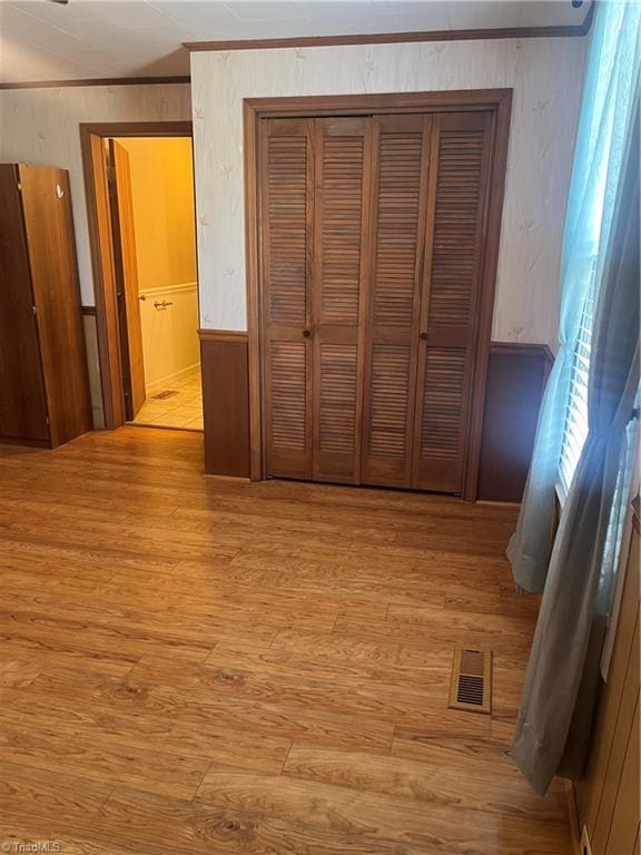 interior space with crown molding, a closet, and light wood-style flooring