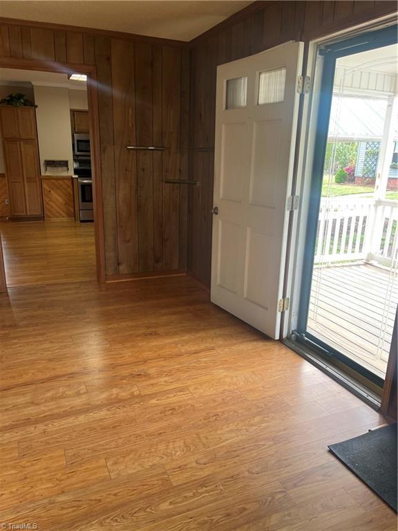 interior space with wood walls and light wood-style floors