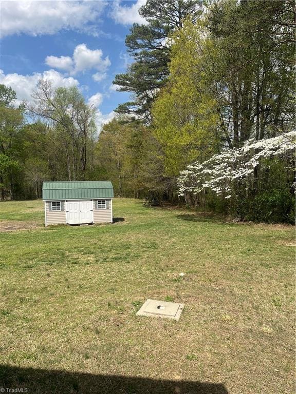 view of yard featuring an outbuilding and a shed