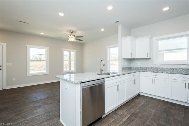 kitchen featuring white cabinetry, sink, stainless steel dishwasher, and light stone counters