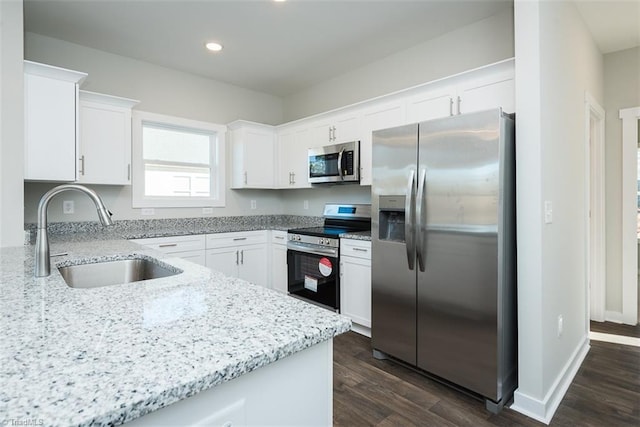 kitchen featuring sink, dark wood-type flooring, stainless steel appliances, light stone counters, and white cabinets