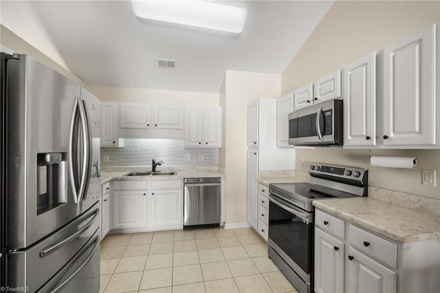 3972 Creekside Ct, Winston-Salem, NC 27127 - kitchen featuring appliances with stainless steel finishes, a sink, light countertops, light tile patterned floors, and white cabinetry