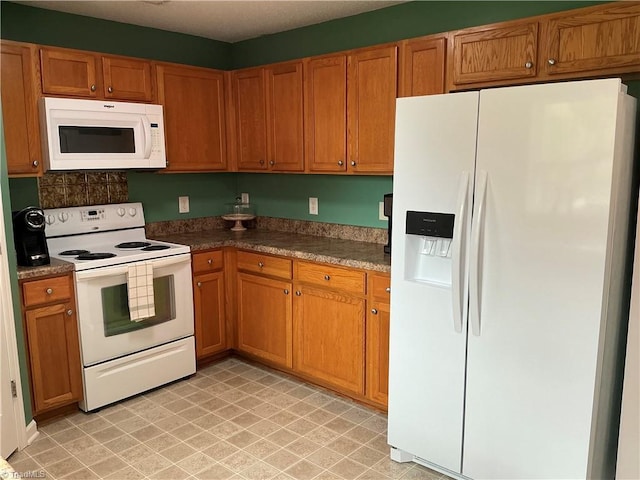 10 Dunlevy Way, Greensboro, NC 27455 - kitchen featuring white appliances, brown cabinetry, and dark countertops
