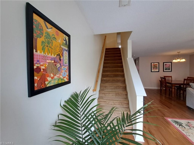 10 Dunlevy Way, Greensboro, NC 27455 - staircase featuring a chandelier, wood finished floors, and baseboards