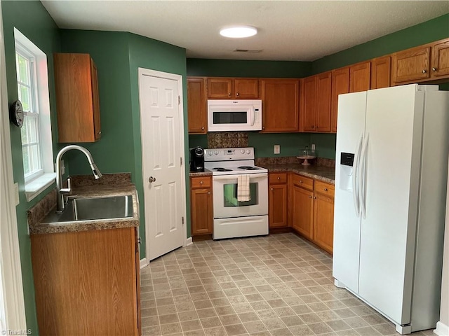 10 Dunlevy Way, Greensboro, NC 27455 - kitchen with white appliances, a sink, and brown cabinetry