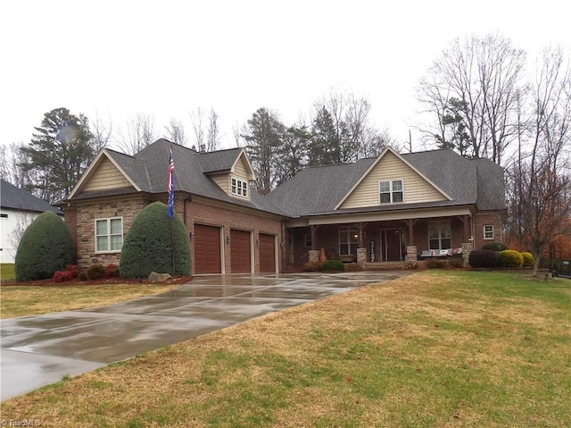 view of front of home featuring a porch, a garage, and a front lawn